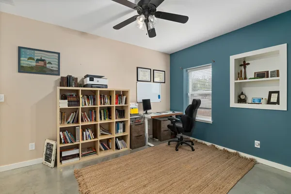 a view of a workspace with furniture and a bookshelf