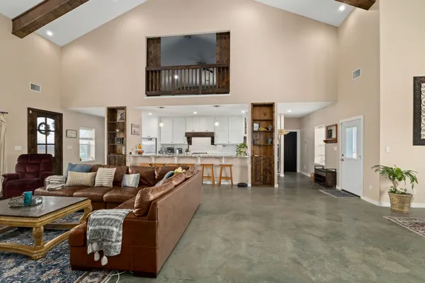 a living room with furniture a flat screen tv and kitchen view
