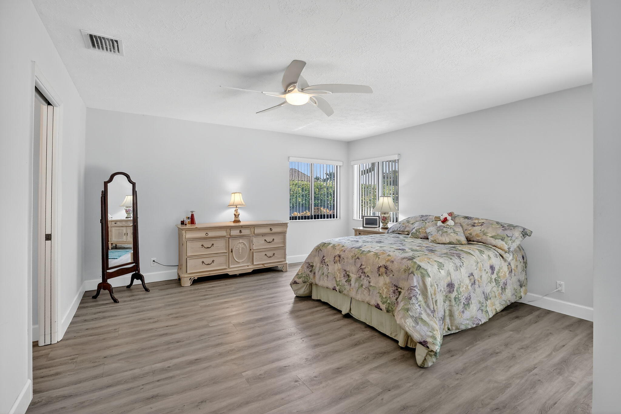 13150 Southwest 16th Court Davie, FL 33325 - Photo 19 of 59 a spacious bedroom with a bed a chandelier and dresser