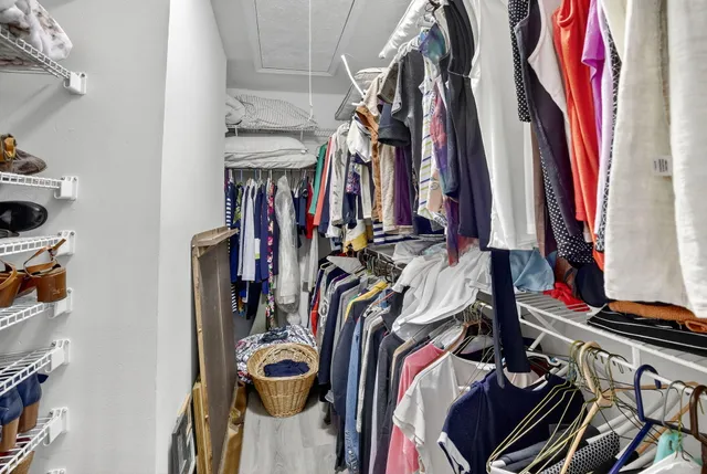 a bedroom with a bed and a lamp on the dresser