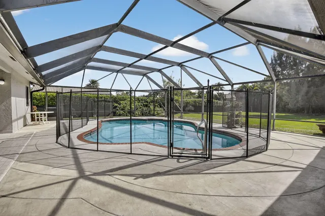 a view of a green field with trees in the background