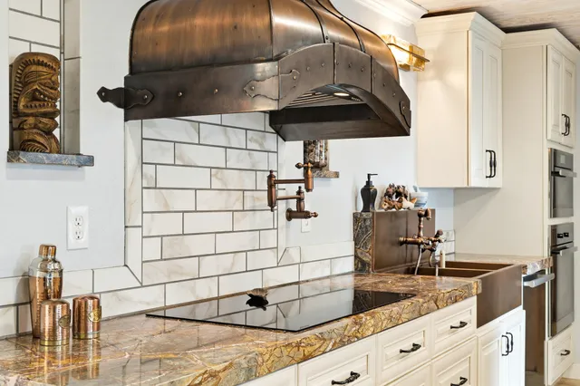 a kitchen with stainless steel appliances kitchen island granite countertop a sink and stove