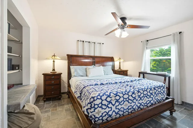 a bedroom with a bed and a large window