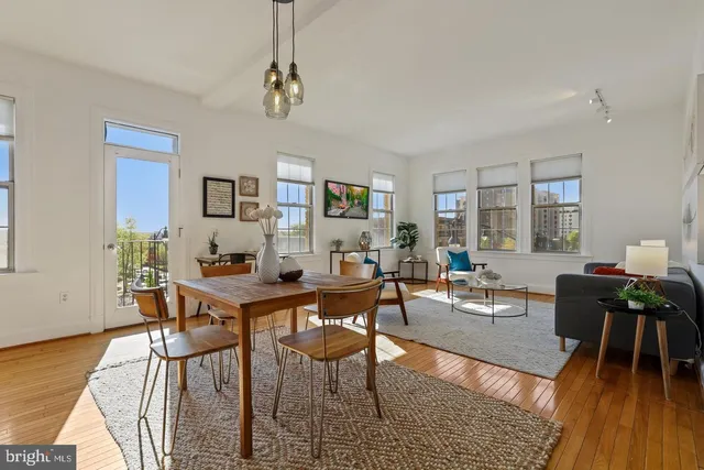 a living room with furniture a wooden floor and a chandelier