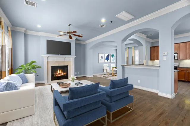 a living room with furniture a flat screen tv and a fireplace