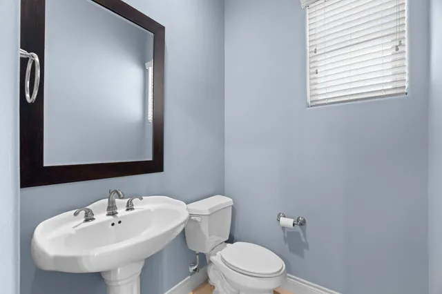 a bathroom with a sink mirror and toilet