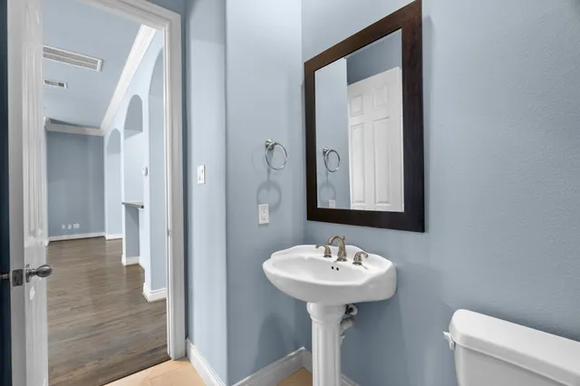 a bathroom with a sink mirror and toilet