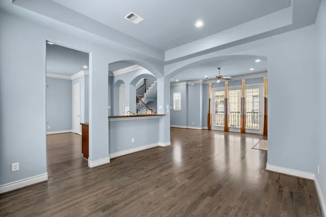 a view of a room with wooden floor and a kitchen