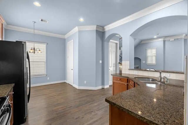 a kitchen with stainless steel appliances granite countertop a sink and a refrigerator