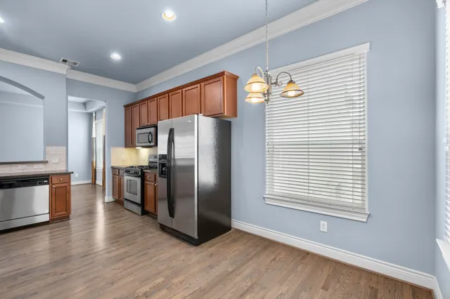 a kitchen with stainless steel appliances a refrigerator and a stove top oven