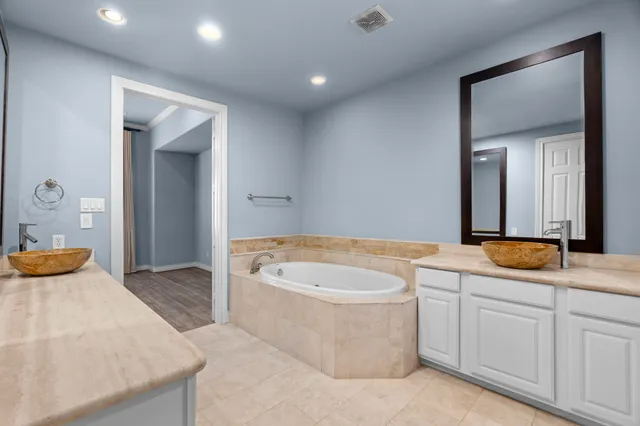 a spacious bathroom with a granite countertop sink and a mirror
