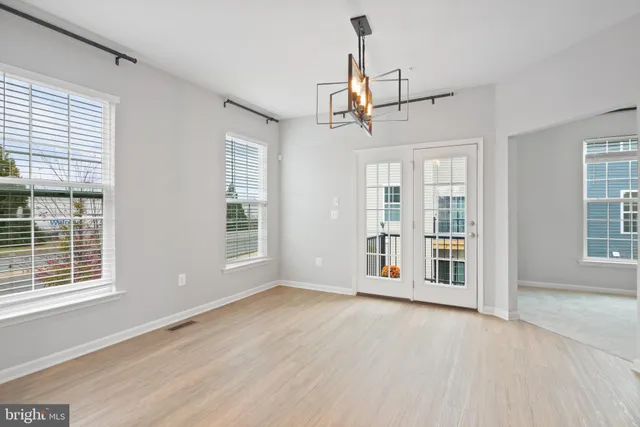 a view of a livingroom with wooden floor and windows