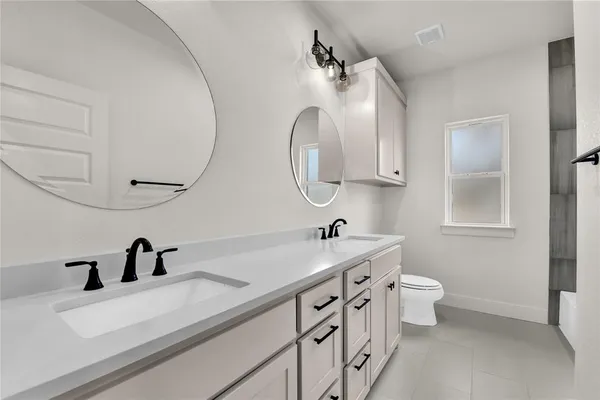 a bathroom with a double vanity sink and mirror