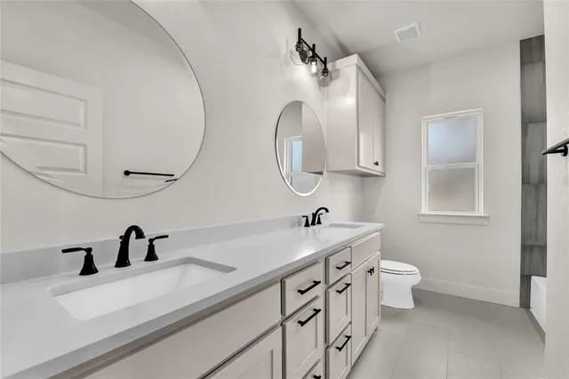 a bathroom with a double vanity sink and mirror