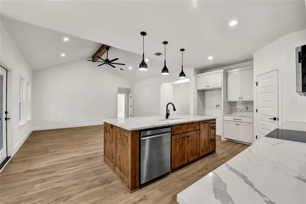 a large kitchen with stainless steel appliances lots of counter space sink refrigerator and cabinets