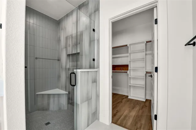 a bathroom with a glass shower door and a bathroom sink