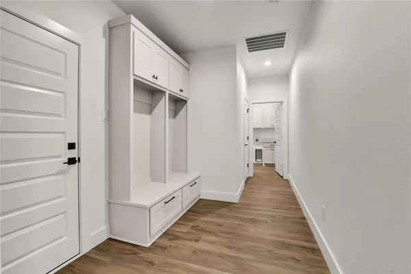 a view of a hallway with wooden floor and closet