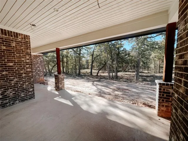 a view of empty room with wooden floor and outdoor seating