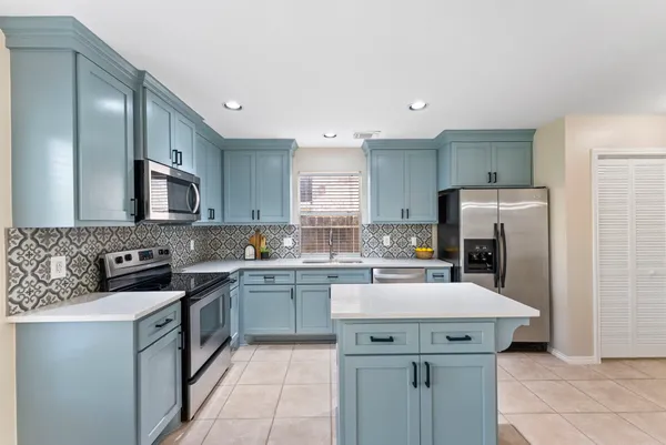 a kitchen with a sink a counter top space stainless steel appliances and cabinets