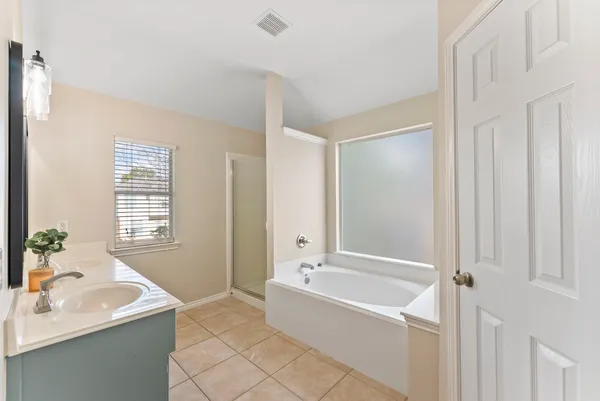 a bathroom with a bathtub shower and a sink