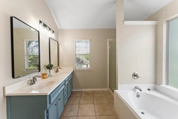 a bathroom with a tub sink double and mirror