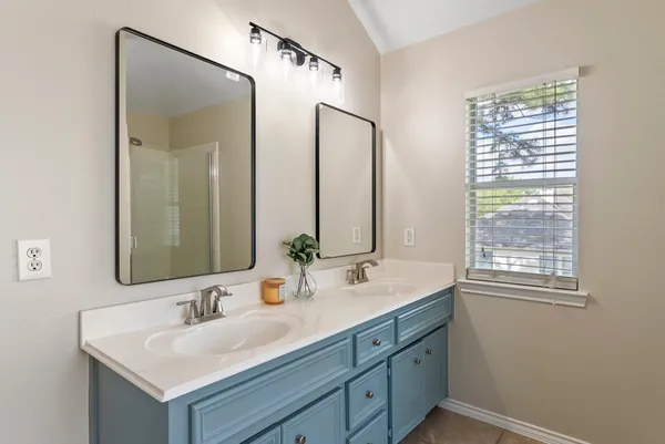 a bathroom with double sink and a mirror