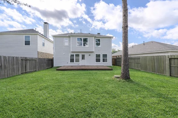 a view of a house with backyard and a tree