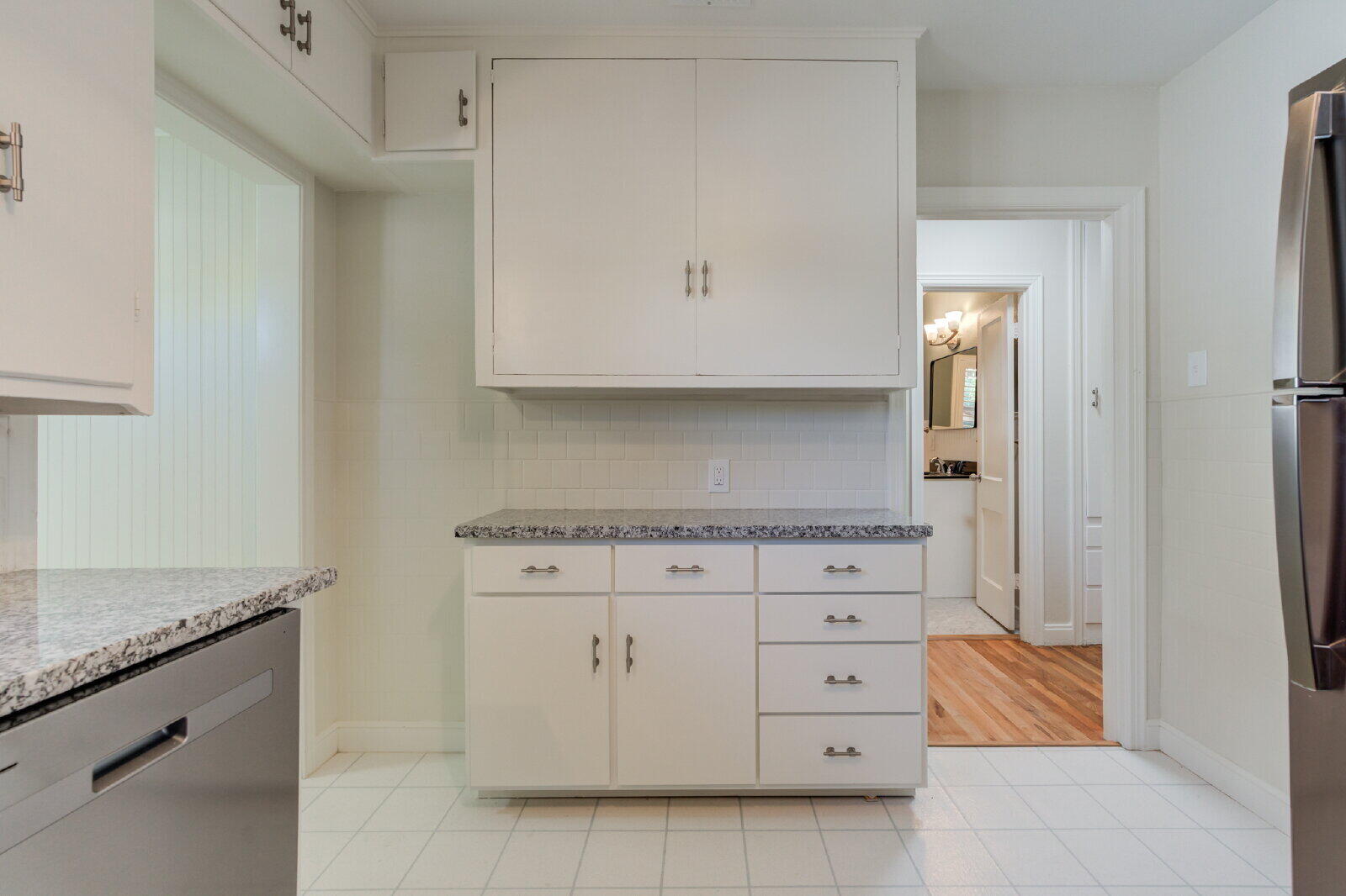 2710 27th Street Lubbock, TX 79410 - Photo 17 of 38 a kitchen with granite countertop white cabinets and white appliances