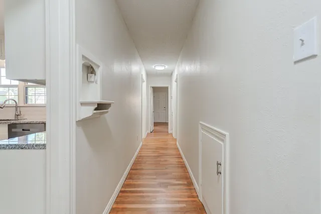 a view of a hallway with wooden floor and staircase