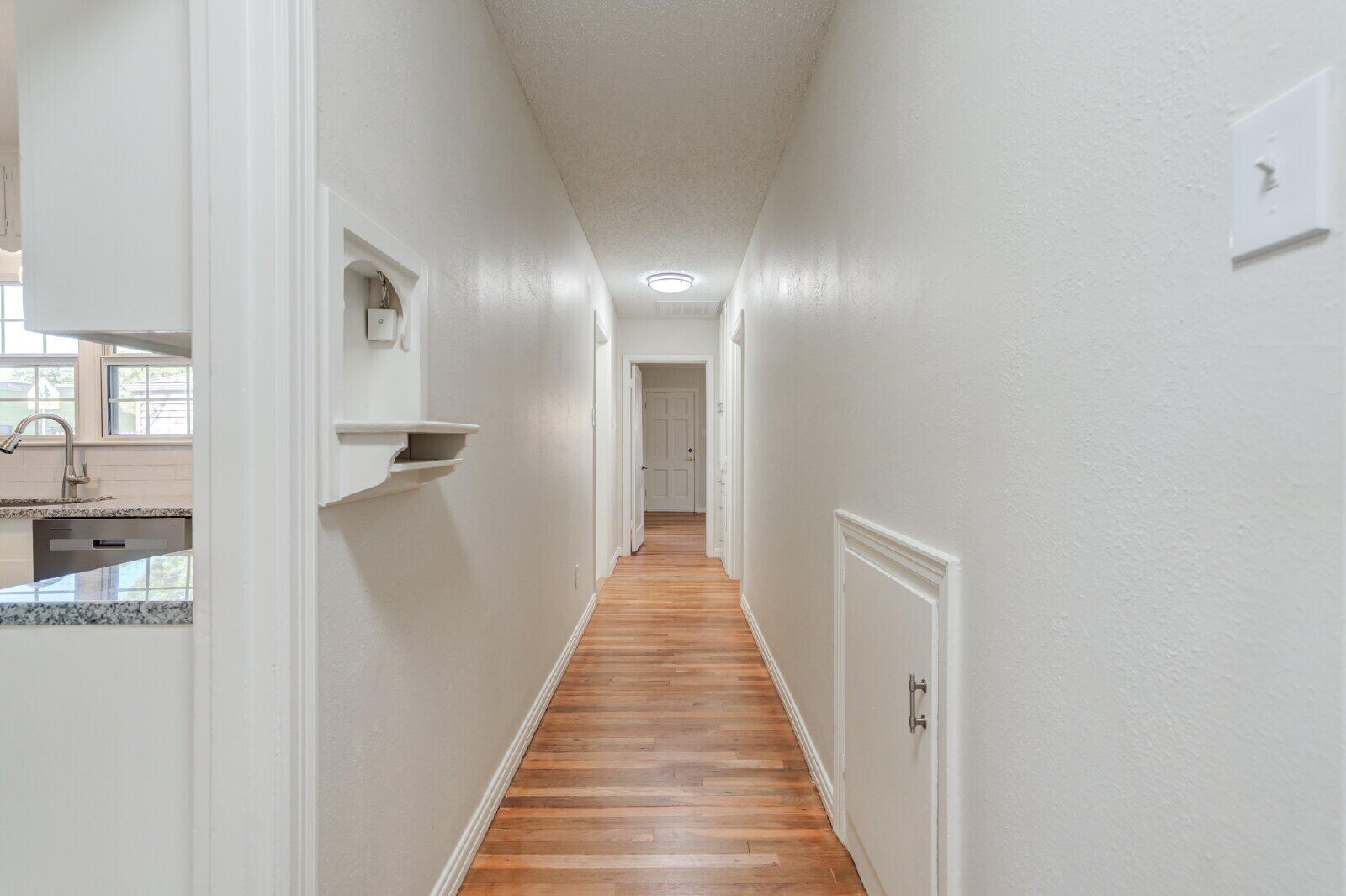 2710 27th Street Lubbock, TX 79410 - Photo 25 of 38 a view of a hallway with wooden floor and staircase