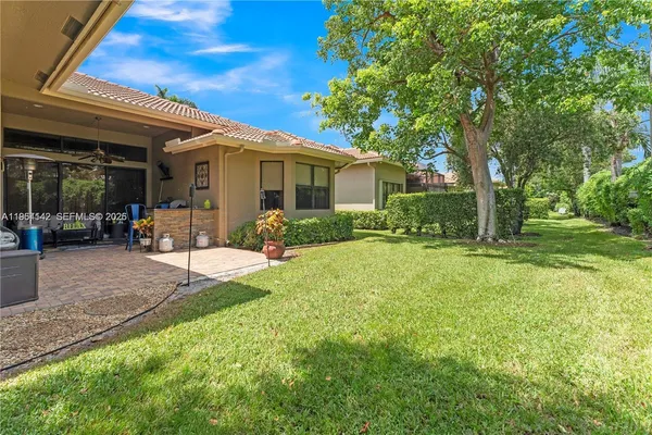 a view of a house with backyard and a tree