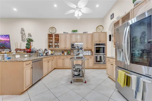 a kitchen with stainless steel appliances kitchen island granite countertop a refrigerator and microwave