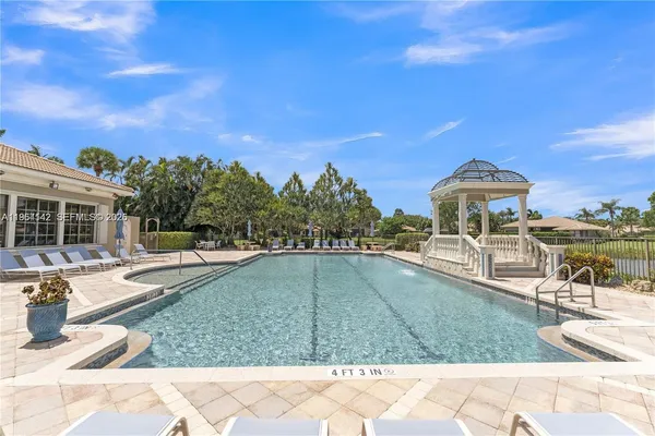 a view of a swimming pool with two chairs in a patio