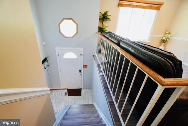 a view of a hallway with wooden floor and staircase