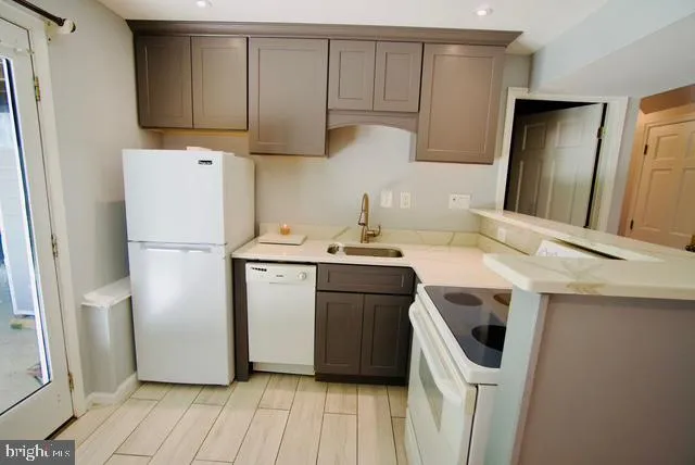 a kitchen with a refrigerator sink and cabinets