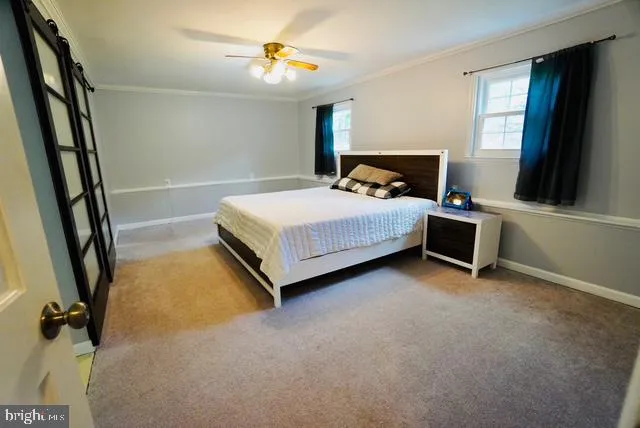 a bedroom with a bed and a flat tv screen on the dresser
