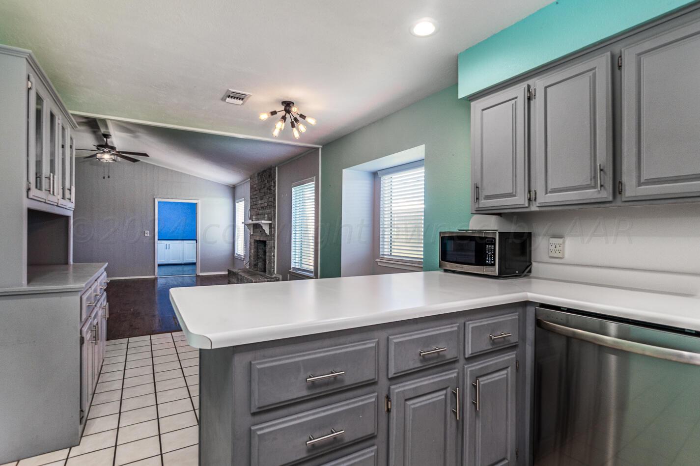 8012 Simpson Drive Amarillo, TX 79121 - Photo 11 of 28 a view of a kitchen with kitchen island a sink stainless steel appliances cabinets and a counter top space