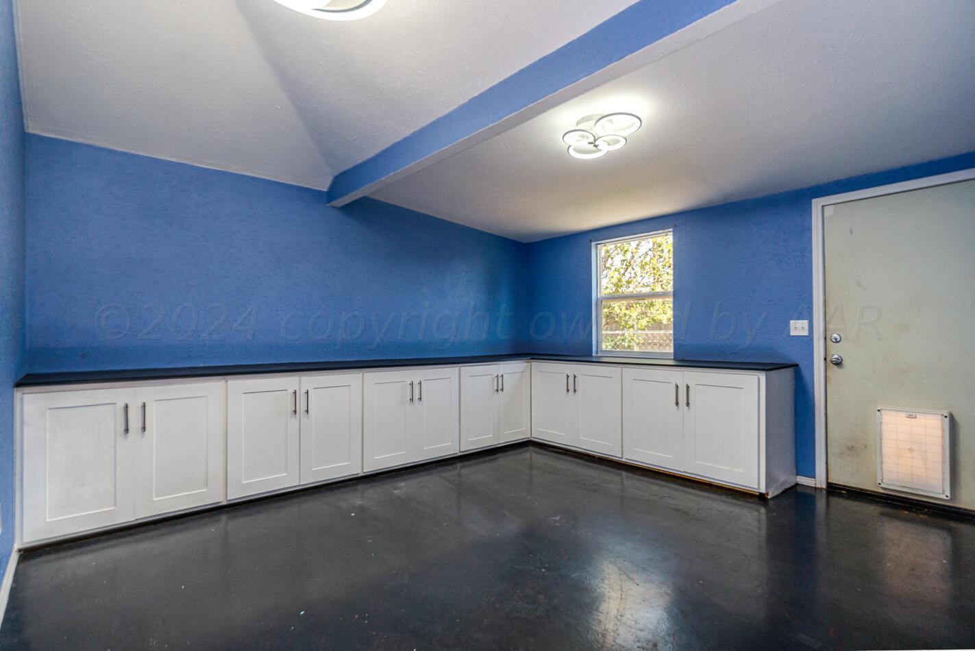 8012 Simpson Drive Amarillo, TX 79121 - Photo 13 of 28 a view of an empty room with wooden floor and cabinet