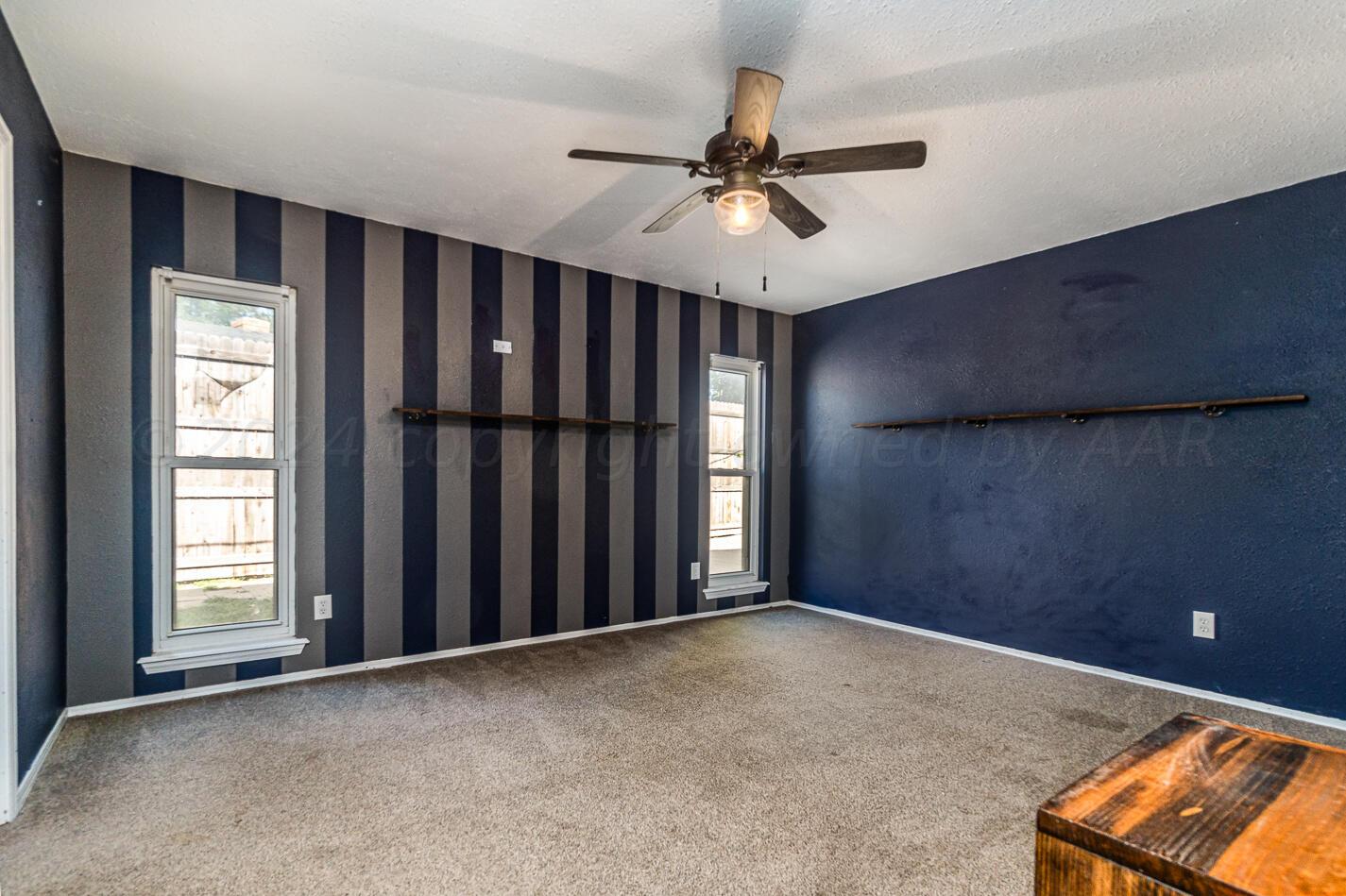 8012 Simpson Drive Amarillo, TX 79121 - Photo 15 of 28 an empty room with windows and fan