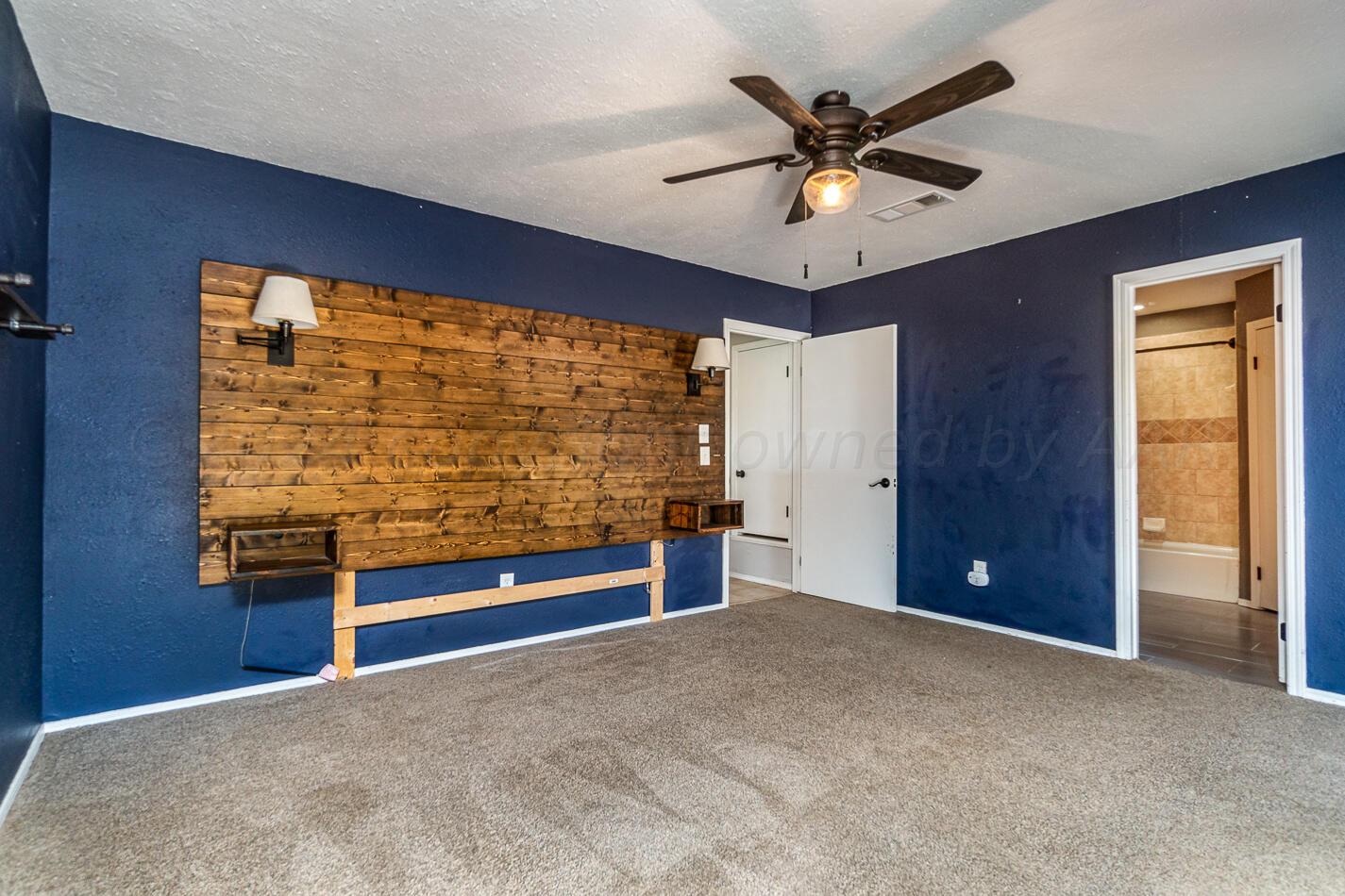 8012 Simpson Drive Amarillo, TX 79121 - Photo 16 of 28 a view of an empty room with a ceiling fan and bathroom view
