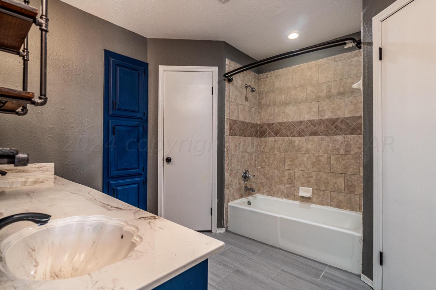 8012 Simpson Drive Amarillo, TX 79121 - Photo 17 of 28 a bathroom with a bathtub and a sink
