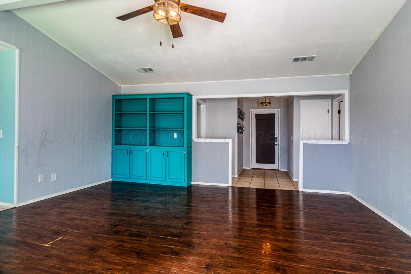 8012 Simpson Drive Amarillo, TX 79121 - Photo 6 of 28 a view of an empty room with a window and wooden floor