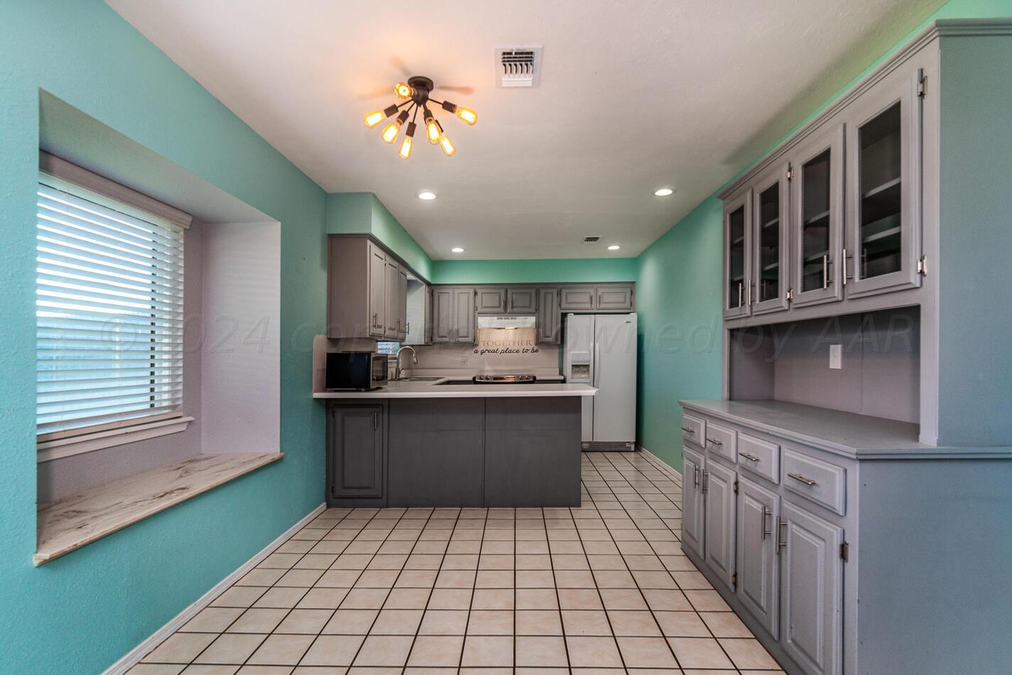 8012 Simpson Drive Amarillo, TX 79121 - Photo 8 of 28 a kitchen with stainless steel appliances granite countertop a refrigerator and a sink