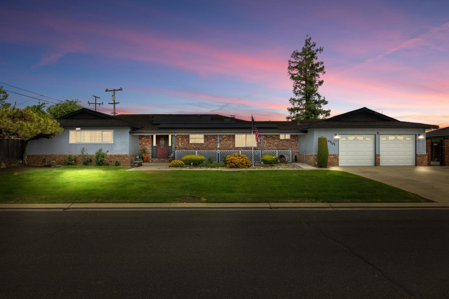 a front view of a house with a garden and yard