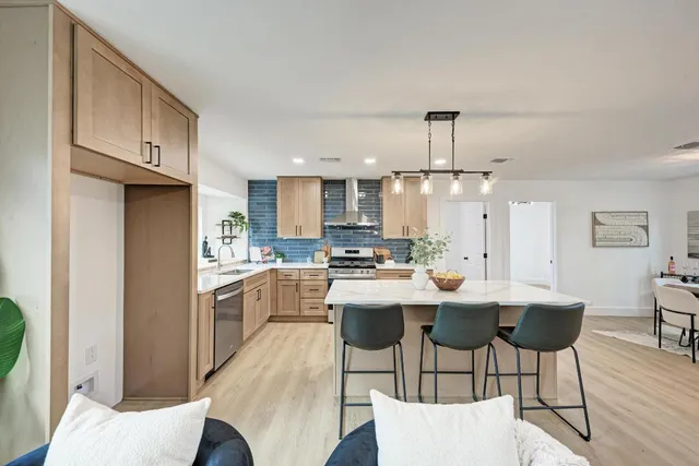 a kitchen with refrigerator a sink and chairs