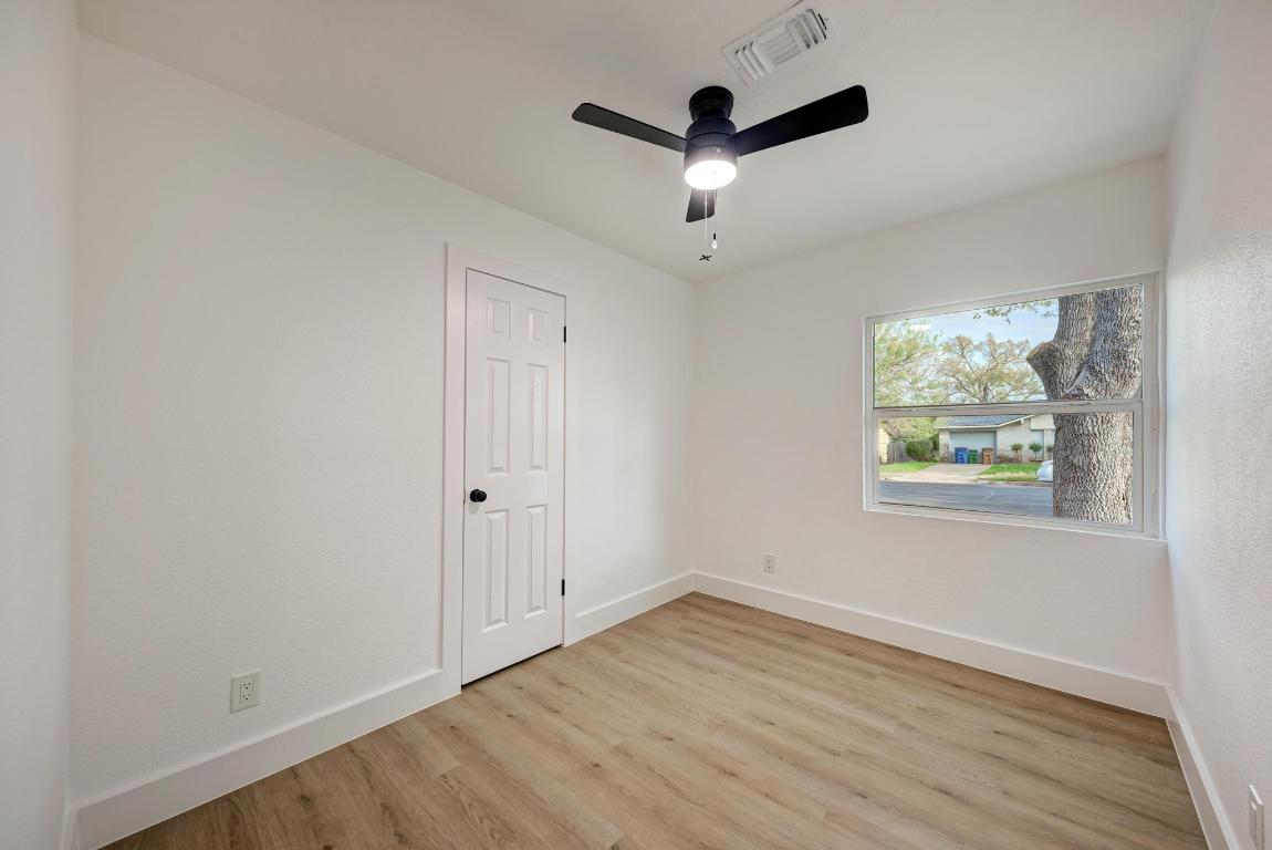 5106 Regency Drive Austin, TX 78724 - Photo 24 of 37 an empty room with wooden floor ceiling fan and windows