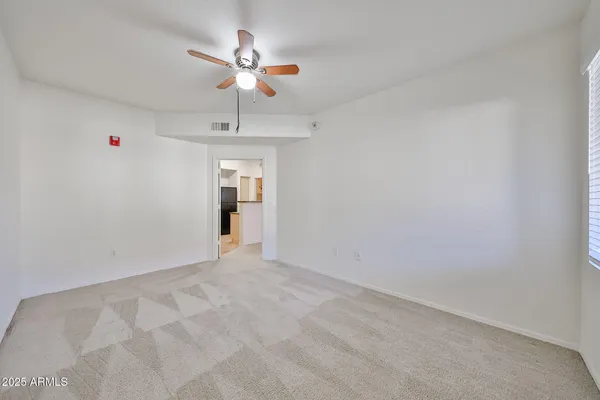 a view of an empty room with a chandelier fan