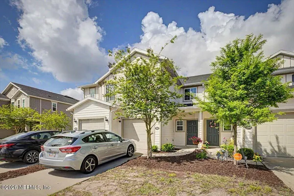 an empty room with wooden floor chandelier and windows