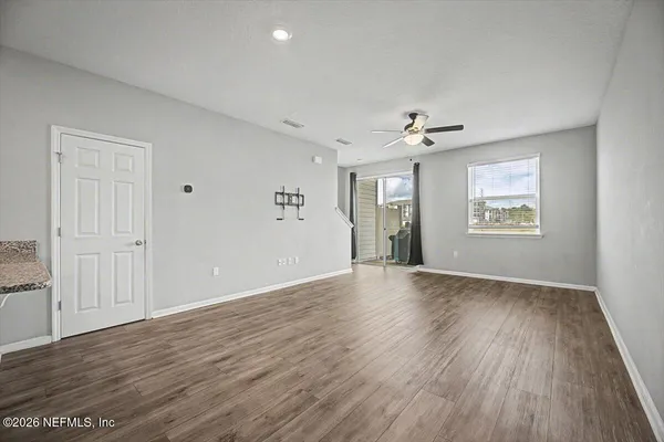 an empty room with a window and a fan