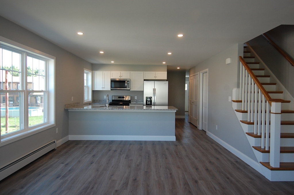 9 Bolton Road, Unit N Dartmouth, MA 02748 - Photo 3 of 19 a view of kitchen with stainless steel appliances granite countertop refrigerator oven a stove top oven with wooden floors and cabinets